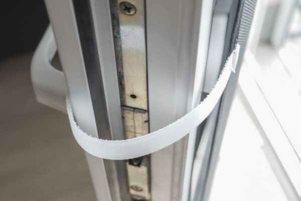 Nahaufnahme einer Türschließe aus Metall, installiert an einer Holztür, zeigt die Verbindungsdetails und Mechanismen.