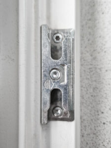 Detaillierte Nahaufnahme einer robusten Fensterschließe, die speziell für verbesserten Hitzeschutz konzipiert ist, installiert an einem Fensterrahmen.