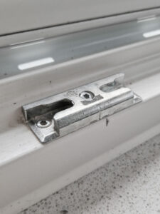 Nahaufnahme einer hochwertigen Türschließe aus Metall an einer geschlossenen Tür, fokussiert auf Mechanismus und Montagedetails.